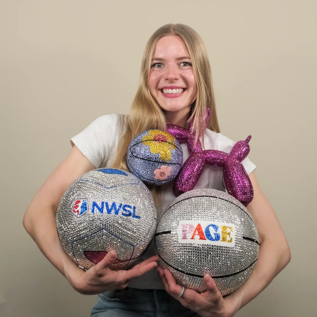 Lauren holding rhinestoned NWSL, basketball and balloon dog pieces